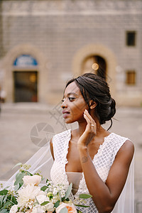 在意大利佛罗伦萨举行的婚礼 穿着白色连衣裙和长面纱的非洲裔美国新娘 新娘捧着华丽的花束花朵混血皮肤捧花亲热主义魅力投标街道绅士图片