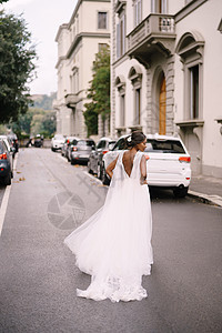 意大利佛罗伦萨的婚礼 非裔美籍新娘 回到镜头前 穿着白色衣服 长着面纱 在街上走在路上亲热混血大男子皮肤种族投标胡子婚纱魅力发型图片
