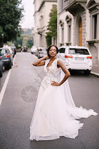 在意大利佛罗伦萨的婚礼上 穿着白色礼服和长面纱的非裔美籍新娘在街上走在路边婚纱投标发型皮肤绅士夫妻魅力庆典混血汽车图片