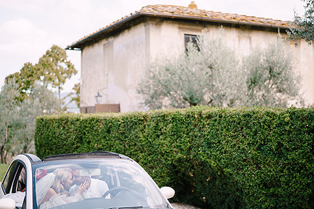 美丽的新娘和新郎在佛罗伦萨附近的托斯卡纳意大利老别墅前 用敞篷车把额头伸向前额庆典内饰男人挡风玻璃汽车女士婚礼酒厂女性仪式图片