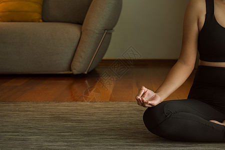 练习瑜伽的年轻女性 穿着黑色运动服的迷人运动女孩 独立的概念 放松女性的幸福 在家或在瑜伽馆近距离锻炼护理技术房间体操女士训练沙图片