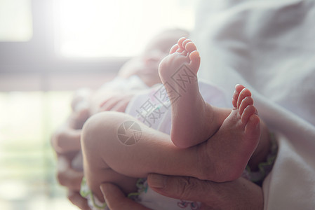 父母抚养着小婴儿 孩子的脚是焦点手指母亲童年生活身体家庭脚趾按摩妈妈新生图片