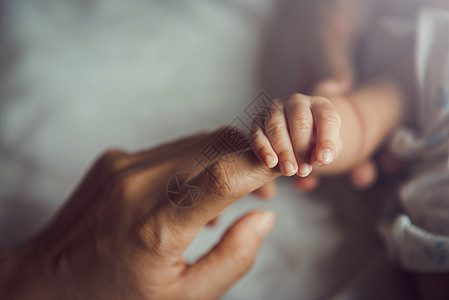 新生婴儿握着母亲的手投标保护父母孩子生活童年女士皮肤健康家庭图片