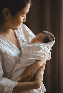 抱着新生婴儿的近身年轻女子图片