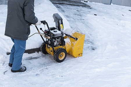 暴风雪过后 男子用造雪机清理车道 在街道上工作的除雪设备 从雪中清理街道 正在下雪车辆季节技术雪堆拖拉机蓝色风暴打扫发动机机械图片