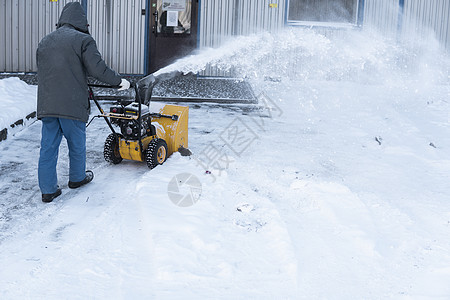 暴风雪过后 男子用造雪机清理车道 在街道上工作的除雪设备 从雪中清理街道 正在下雪男人季节人行道引擎行动降雪工人机械雪堆拖拉机图片