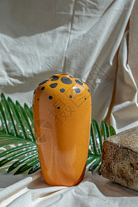 白色纹理桌布上的橙色手工陶瓷花瓶 家居装饰热情家具风格房子织物制品餐具艺术礼物橙子图片