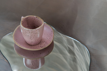 织物纹理桌布上镜子上的粉色手工陶瓷杯家居作品装饰家具玻璃工艺咖啡材料潮人房子背景
