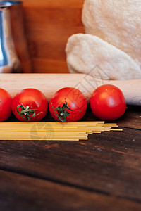 木制餐桌上的意大利意面樱桃西红柿做饭烹饪桌子用餐盘子健康饮食刀具用具香料食物饭馆图片