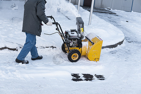 暴风雪过后 男子用造雪机清理车道 在街道上工作的除雪设备 从雪中清理街道 正在下雪人行道发动机引擎机械蓝色男性男人天气车辆打扫图片