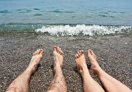 沙滩上的对等双腿游客生活海滩皮肤支撑棕褐色鹅卵石海浪海洋成年人图片