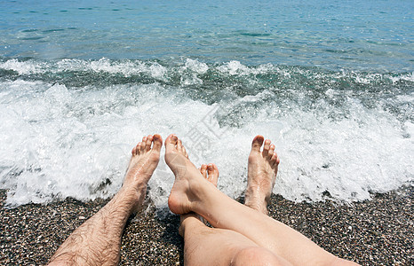 沙滩上的对等双腿游客海岸海滩皮肤闲暇脚趾成年人休闲海洋支撑图片