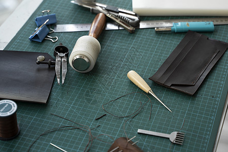 男士手在他的工作室里制作皮革钱包 与棕色天然皮革的工作过程 拿着制作工具的工匠职业工艺品产品鞋类机器缝纫拳头前锋裁缝材料图片