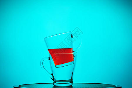杯子上装着茶 一个在另一间里面 蓝色背景的静止生命图片