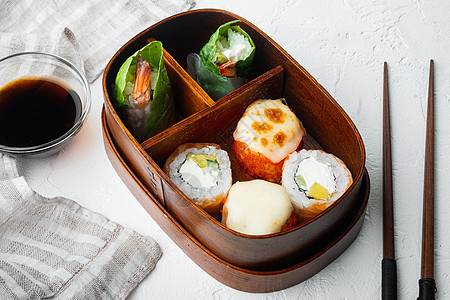 带寿司卷的自制寿司本托盒 以白石为背景图片