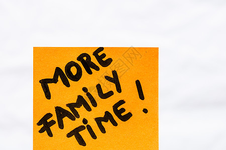 更多的家庭时间笔迹文本特写了 孤立在橙色纸上 复制空间图片