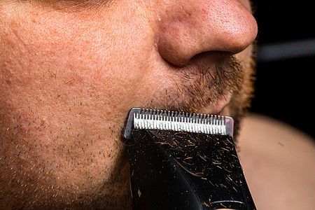 男人用剪发机剃刮胡子或修剪胡子剃须刀刮胡子美容工具化妆品外貌卫生理发师夹子胡须图片