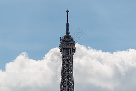 Eiffel 铁塔顶端有白云和蓝天空作为背景图片