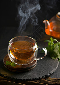 茶叶概念 茶壶和茶茶 以木为背景 茶仪式 在透明杯子里的绿茶文化饮料叶子食物植物生活茶点菜单小样液体图片