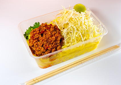带酱汁的意大利面条用塑料包装将食品带回家托盘红色筷子美食蔬菜盒子图片