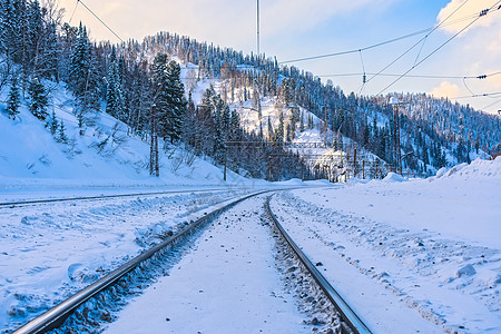 冬季 铁路穿过积雪的山峰图片