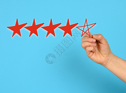 5个红星和一只女性手在蓝背景上画 高评分图片