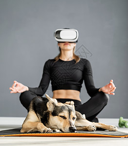身穿运动服 戴着虚拟现实眼镜的年轻女性坐在健身垫上女孩技术成人游戏蓝色创新运动员娱乐运动工具图片