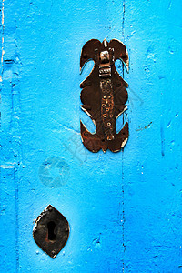 旧的 色彩多彩的蓝色木制门 有铁条入口硬木古董临界点建筑学风化历史乡村合页石头图片