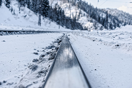 在雪山背景下 铁路铁轨紧靠着积雪山图片