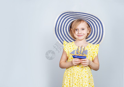 戴宽帽的女孩手里握着玩具船 手很宽航行持有喜悦童年折纸旅行保险横幅女性投资图片