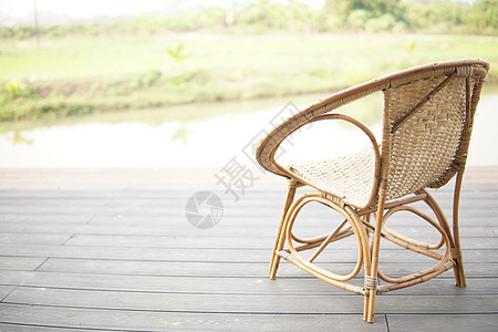 池塘附近阳台露天露台的电动拉坦椅子座位闲暇风格房子木头沼泽花园家具装饰休息图片