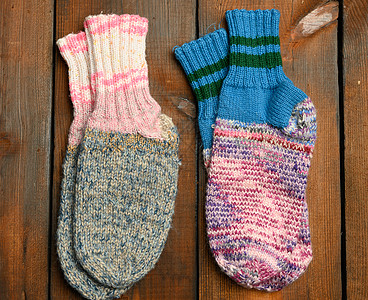 棕色木头背景的一对温暖舒适的编织袜子图片