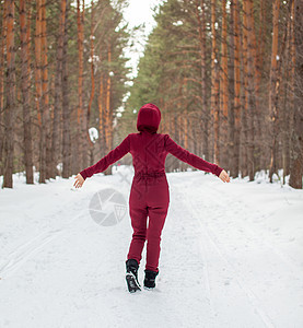 冬天在一片雪覆盖的森林中行走 一个穿红色内衣的女孩天气降雪衣服旅行女性公园森林冻结帽子小路图片