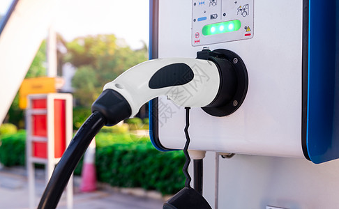 为 EV 电池充电的电动汽车充电站 用于配备电动和混合动力发动机的车辆的插头 电动汽车充电器 清洁能源 EV 汽车的充电点 绿色图片