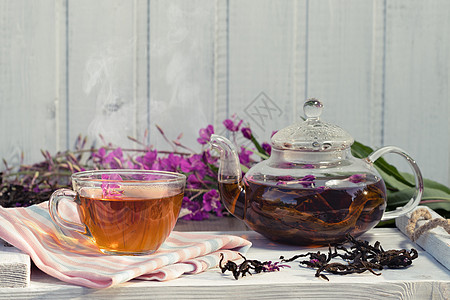 由青草所制成的草药茶壶和杯子中盛开的香味茶叶 复制空间图片
