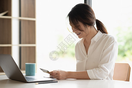女性手持信用卡和智能手机在线支付 使用银行服务 输入信息 购物 在网上商店订购 进行安全支付的照片图片