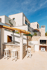阳台烧烤海边别墅的Grill区 一个大庭院 有一个石炉和一个开阔的白石厨房背景
