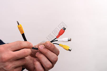 录音视频电缆RCA插孔 在一个人的手中 一个白色背景图片