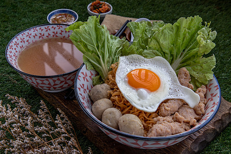 鸡蛋面加猪肉球 薄煎猪肉 炒蛋 蔬菜和碗里的汤盘子文化烹饪餐厅拉面早餐食物美食筷子午餐图片