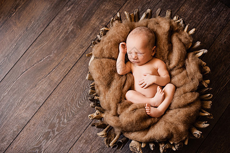 新生婴儿背上睡在棕色篮子里 在新生儿的照相机旁图片