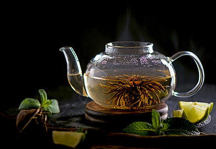 茶叶概念 茶壶和茶茶 以木为背景 茶仪式 在透明杯子里的绿茶植物饮料文化草本植物茶点食物叶子小样生活菜单图片