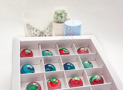 盒内涂有模糊背景和bokoh元素的彩色粉状体面盒装着热辣巧克力糖果盒甜点绘画创造力磨炼盒子黑色框架巧克力产品摄影图片