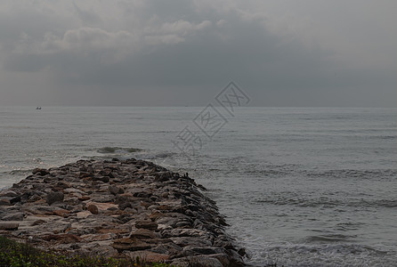 海浪在清晨冲击着 平静海滩的岩石气泡波浪支撑天空海岸海洋假期墙纸蓝色天气图片