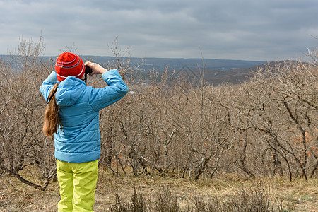 一个秋天的女孩 透过山上的望远镜 后视镜看一眼图片