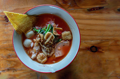 碗里有粉红汤的泰国面条餐厅午餐小吃厨房鱼丸胡椒食物骨汤蔬菜桌子图片