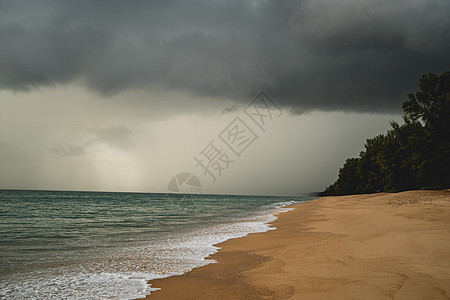 热带海滩有白色沙尘和黑暗的暴风云图片