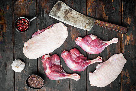 生鸭肉 用旧屠宰刀 在老黑木桌背景上 顶楼高清图片