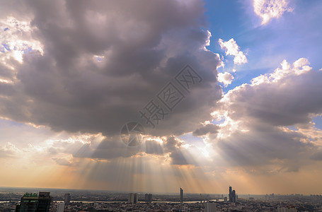 太阳的光芒穿透云层 闪耀在天空中照耀着奔驰的城市市中心射线建筑旅行景观时段天堂晴天天气气候图片