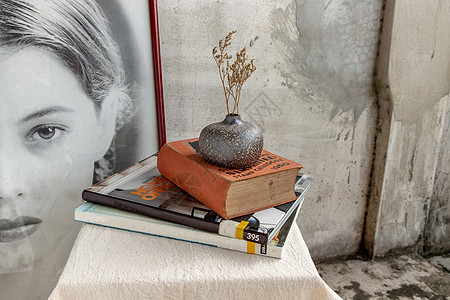 手工陶瓷花瓶中的干花和桌上的书麻布叶子植物工艺房间艺术陶器织物风格潮人图片