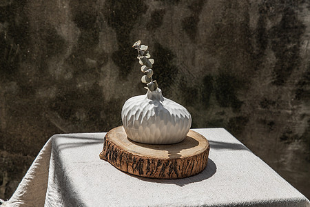木板上手工陶瓷花瓶中的干花工艺植物叶子织物制品潮人客厅印花布热情艺术背景图片